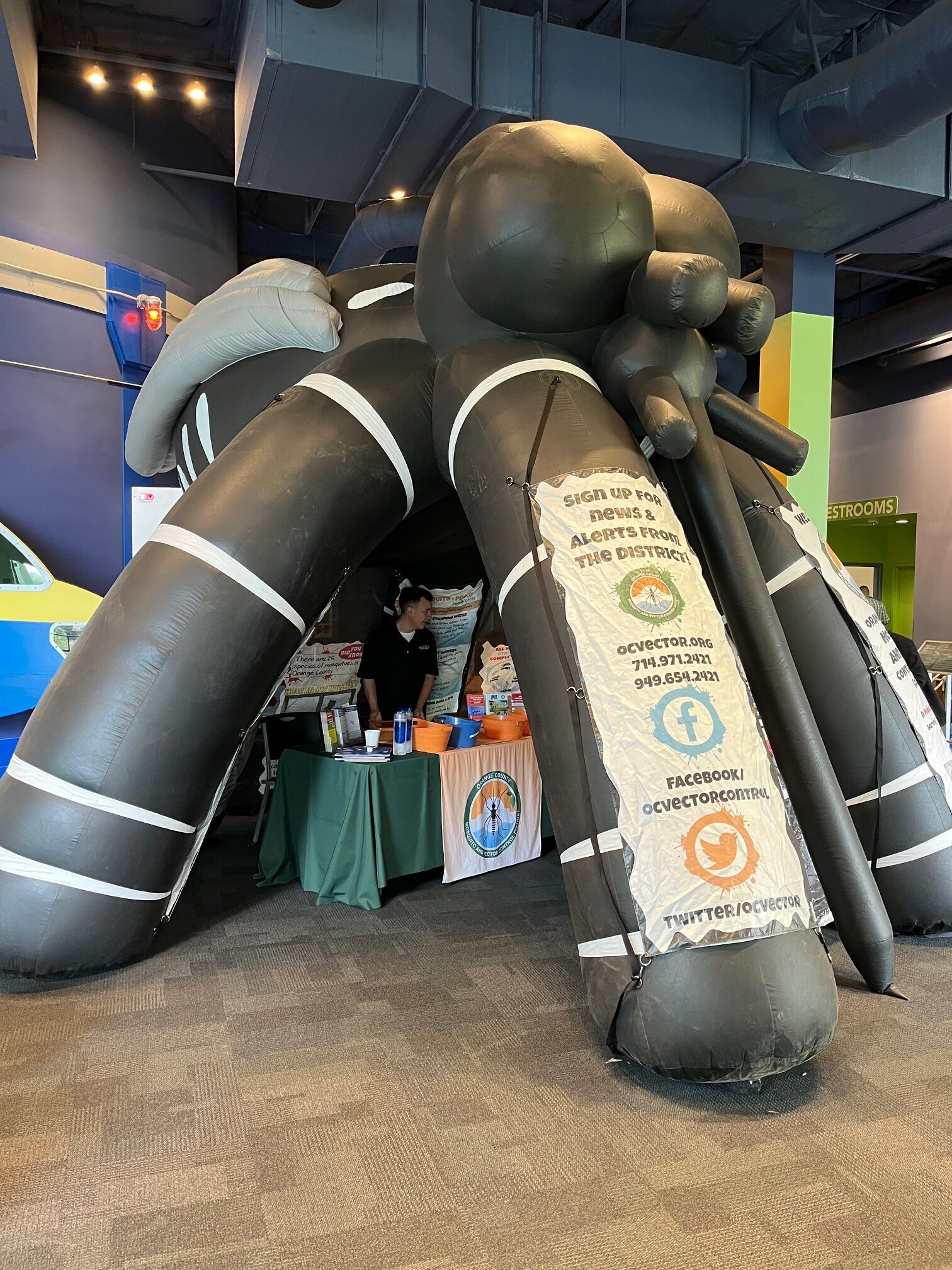 Giant inflatable mosquito with an information table inside.