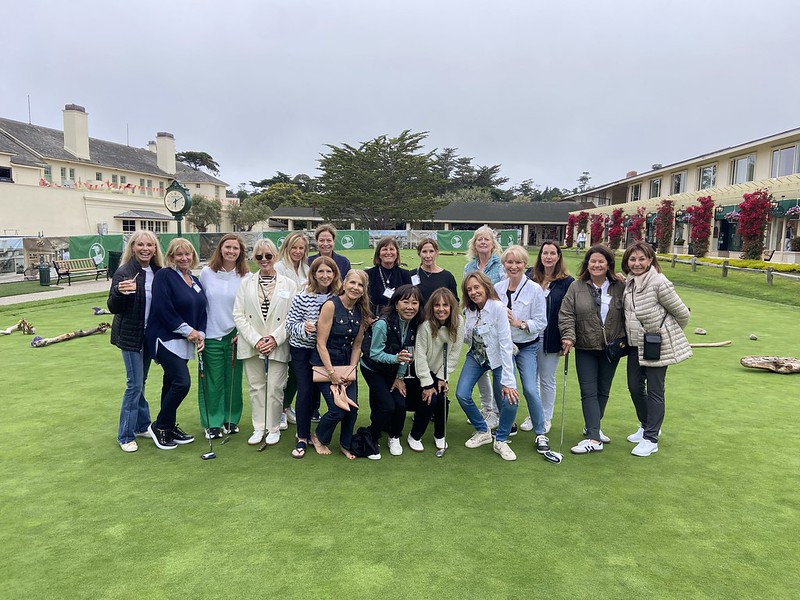 A group photo taking a photo at a golf event.