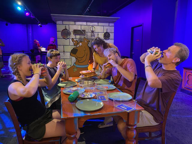 A family enjoying the Scooby Doo exhibit in a museum.