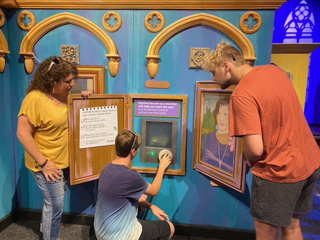 A family playing with interactive parts of a museum exhibit.