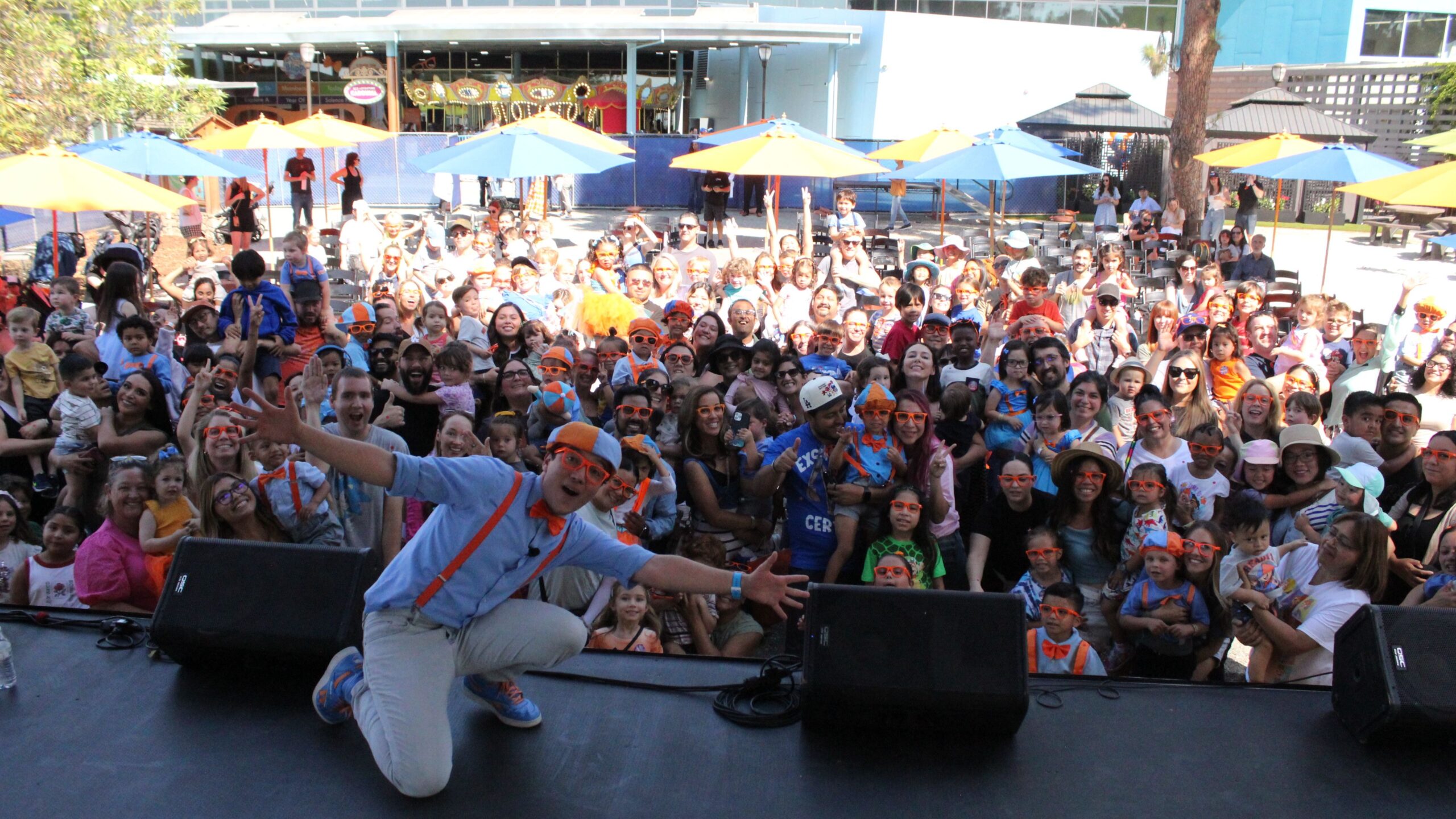 Blippi taking a selfie with the crowd at an event.