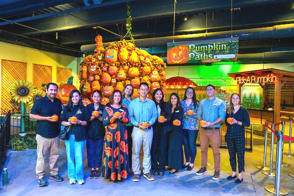 A group photo in front of the Pumpkin Paths exhibit at Discovery Cube Orange County.